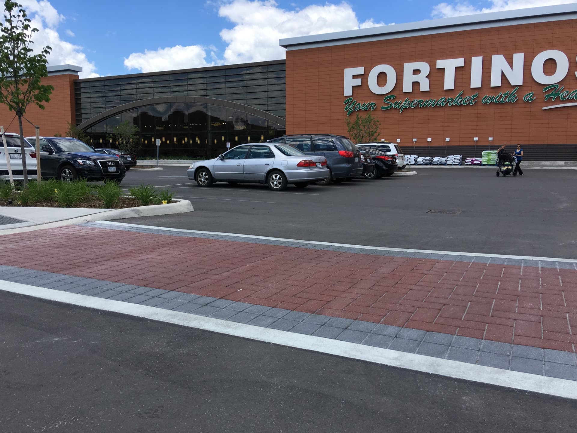 Commercial plaza red brick-pattern pedestrian crossing at a retail entrance in Oakville, Ontario — decorative pavement by HUB Surface Systems