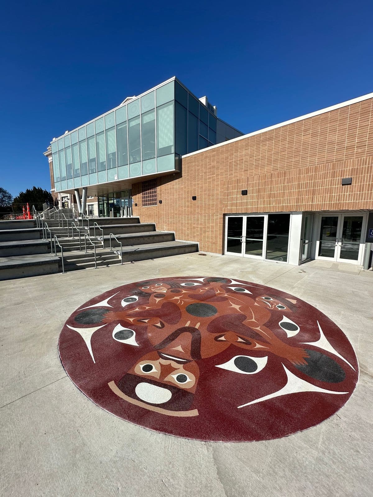 Public art pavement installation — DecoMark and StreetBond custom civic mural and cultural identity street surface at Joyce-Collingwood Skytrain Station.