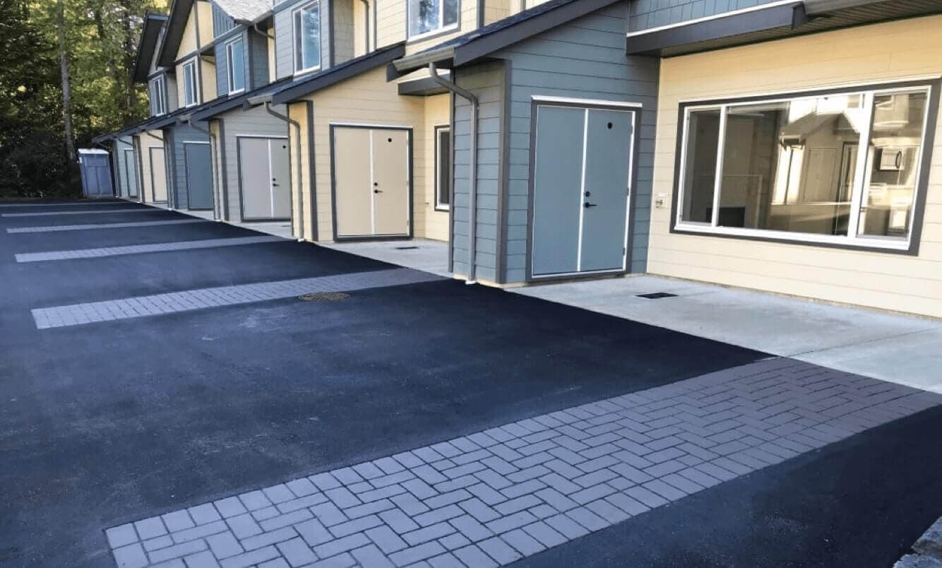 Townhome community paving in stamped asphalt and coloured pavement coating — a strata common entrance, Canada