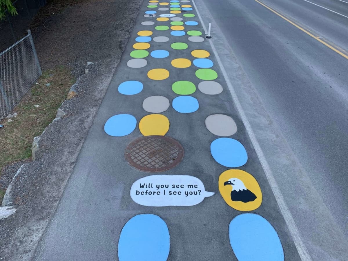 HUB Surface Systems DecoMark decorative pavement graphics — logos, art, and custom pavement design at a cultural art crossing