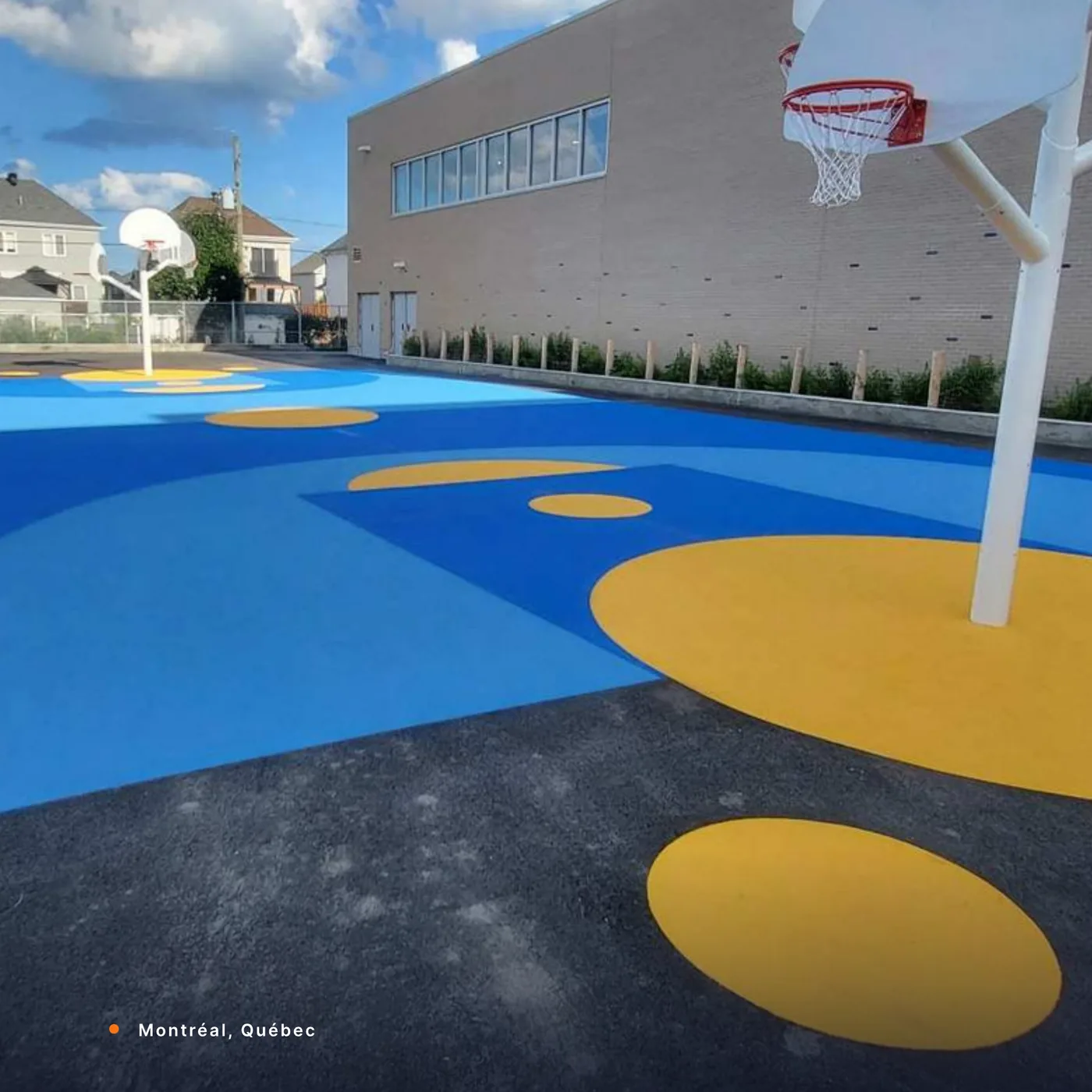 A blue and yellow StreetBond basketball court in Montréal, Québec