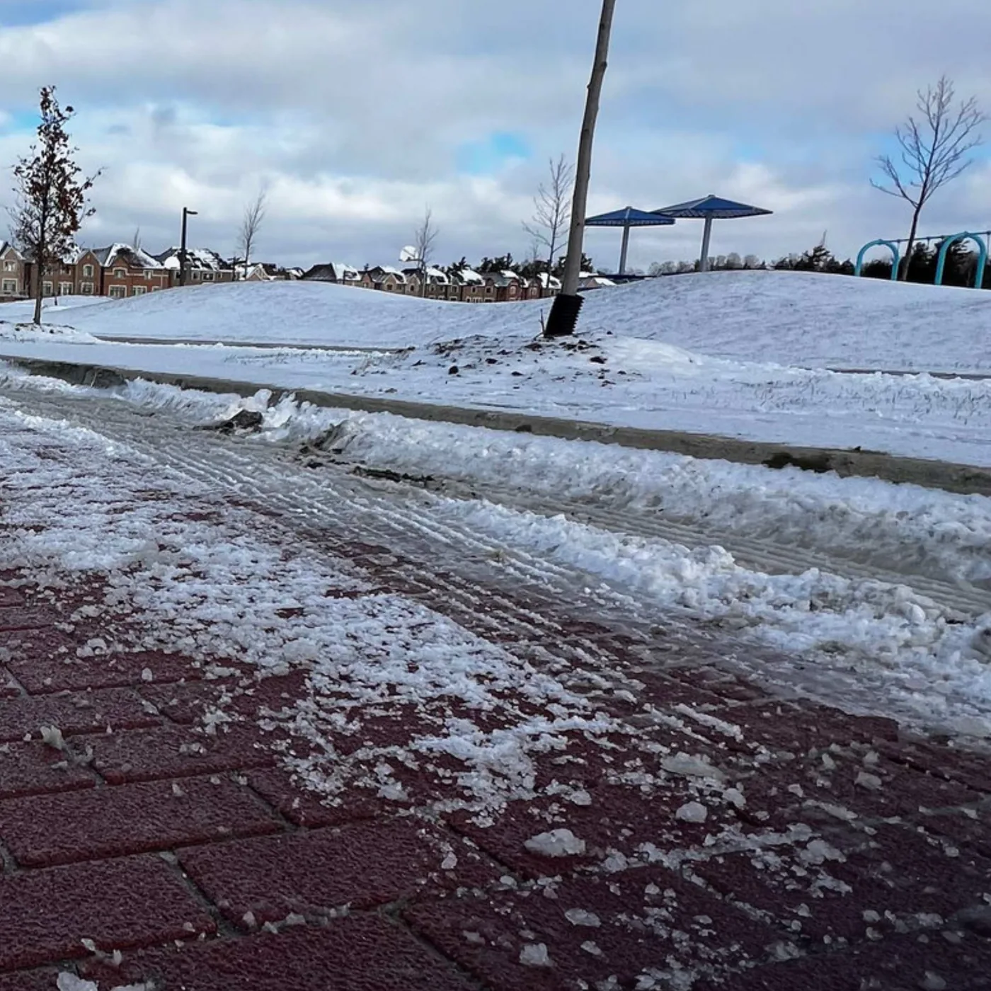A red brick-pattern TrafficPatternsXD surface after a snowplow has passed