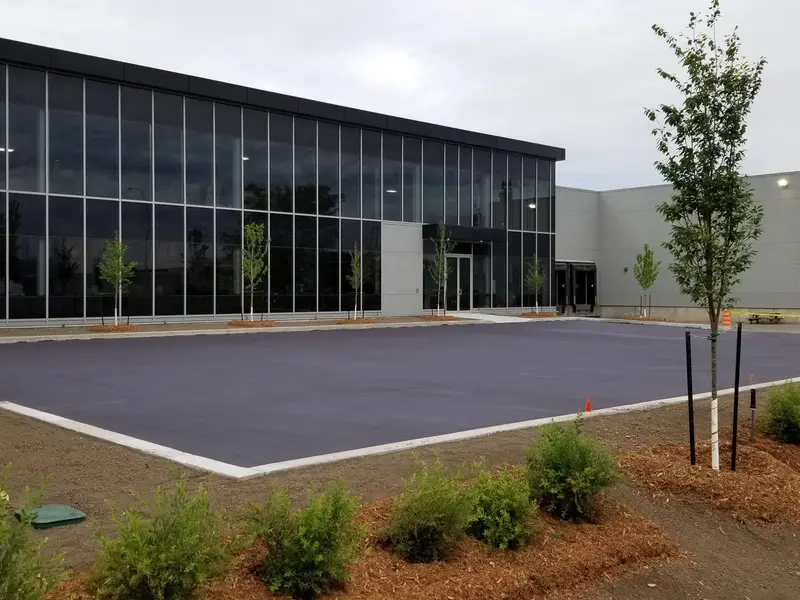 Freshly coated DuraShield parking lot in front of a glass-fronted building