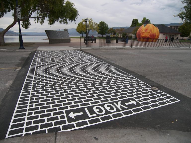 DuraTherm Wayfinding crosswalk with attention indicator and a big orange peach in the background